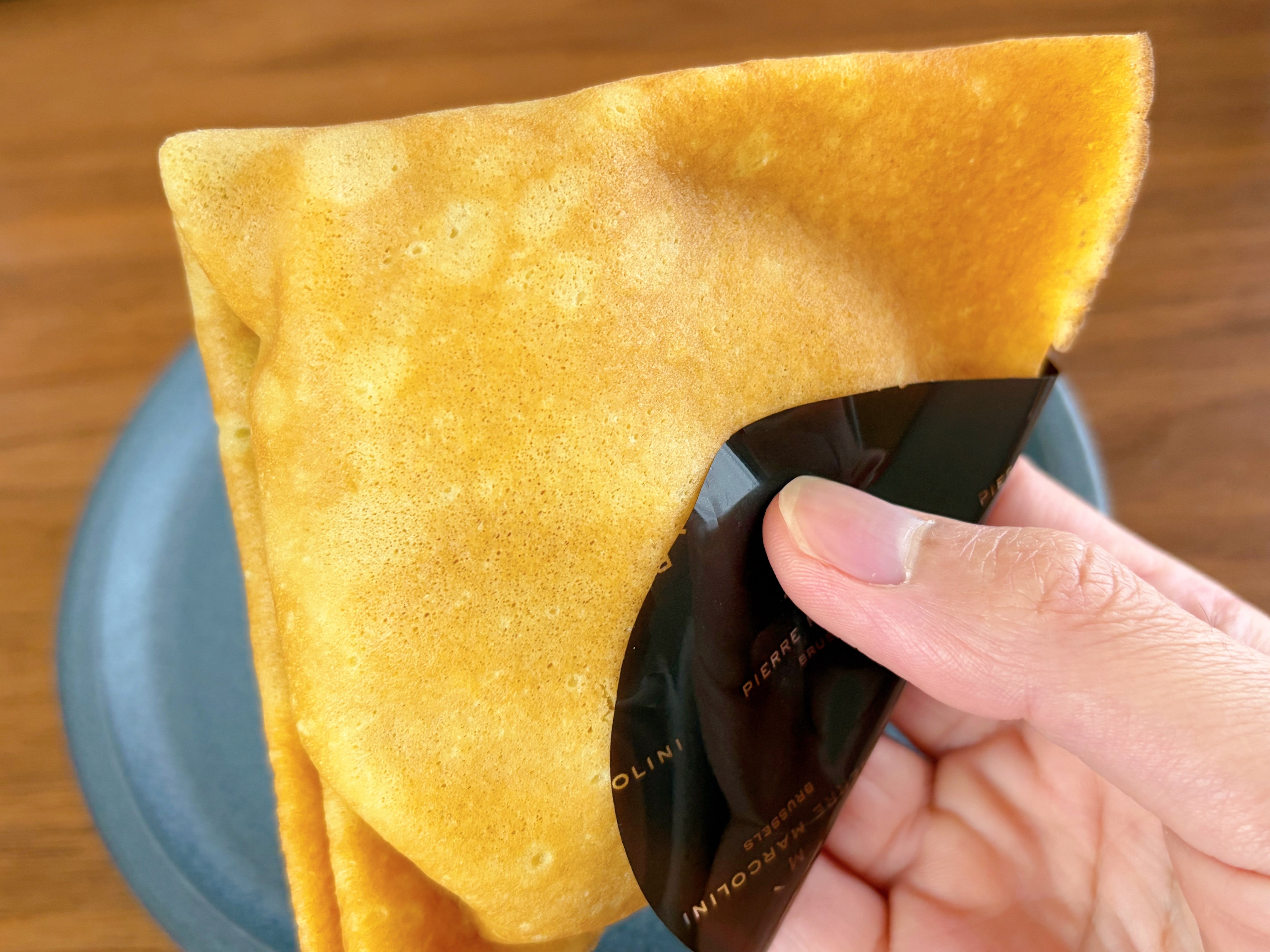 ショコラと洋梨のクレープを手に持った