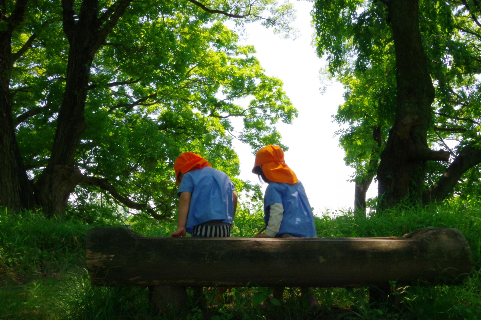 園児がベンチに座っている