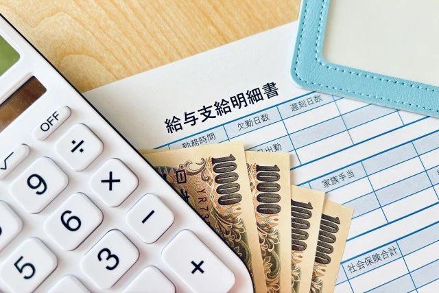 電卓、一万円札、給与支給明細書
