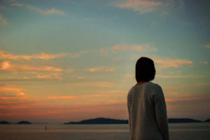 夕焼けを見る女性の後ろ姿