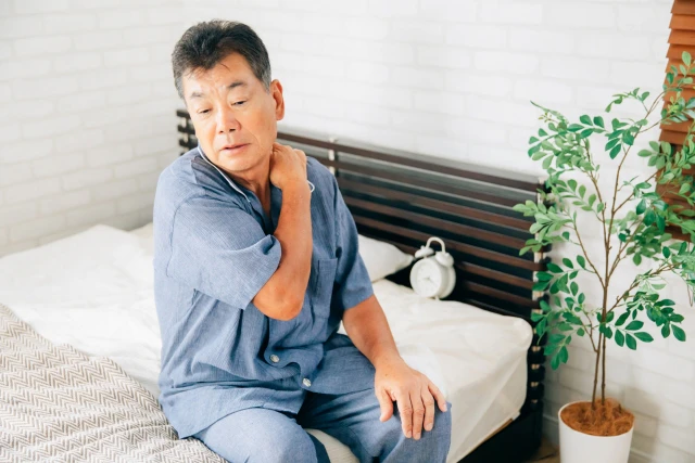 肩に手を当てる男性