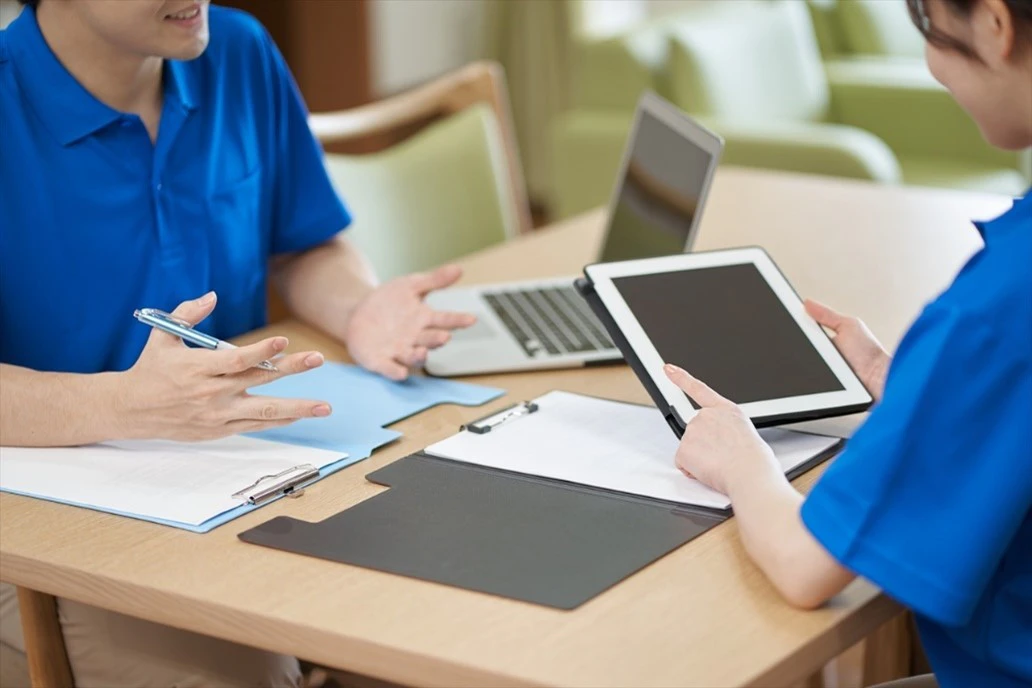 資料を見ながら話し合う男女スタッフ