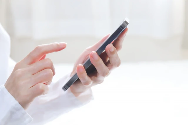 携帯をタップする手