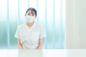 ほほ笑むマスク姿の看護師