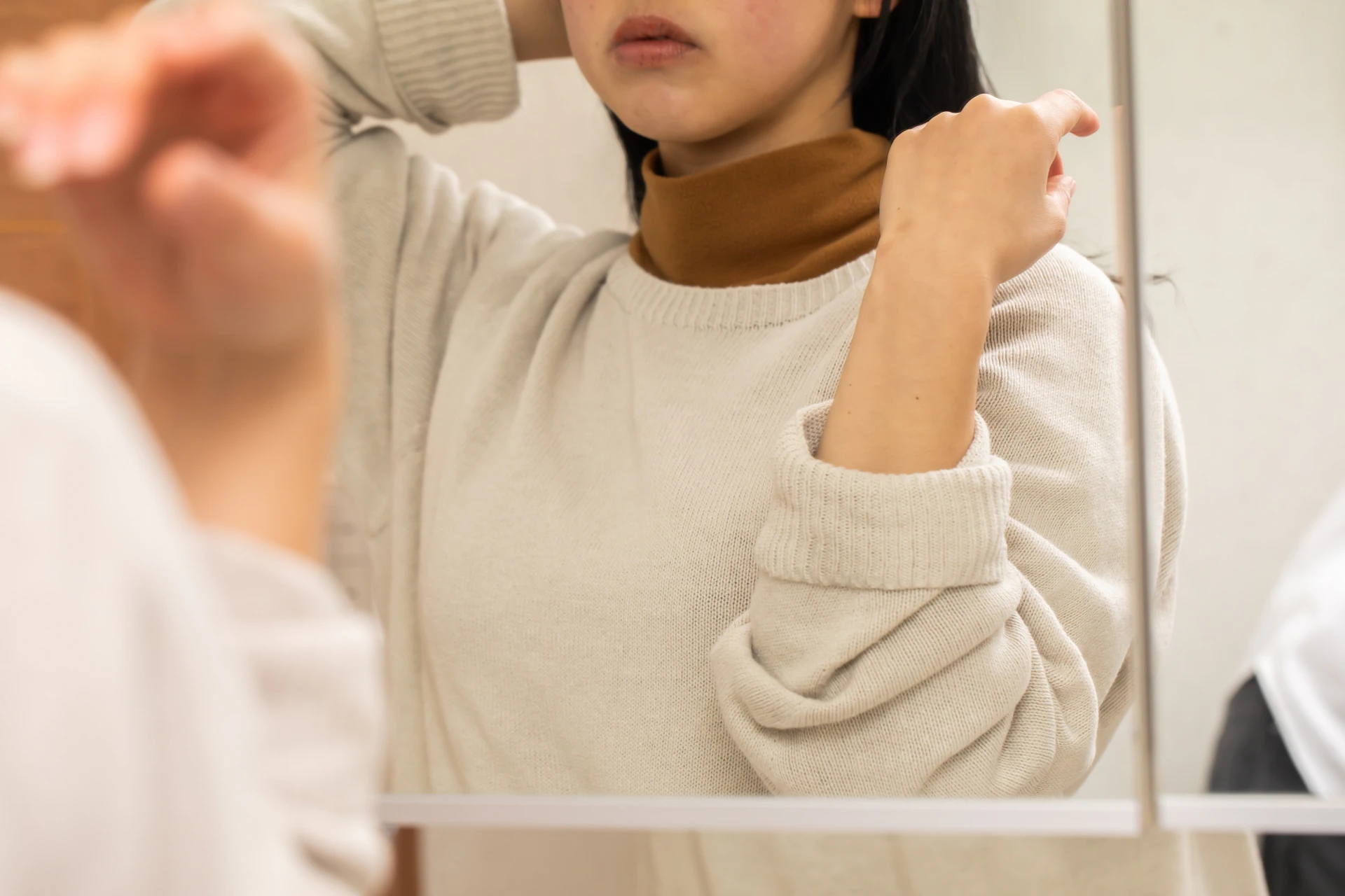 鏡の前で身支度をする女性