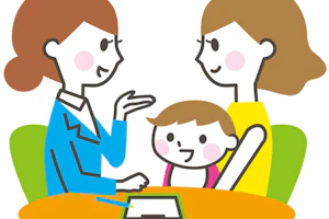 赤ちゃんを抱っこして座っているお母さんと話す女性