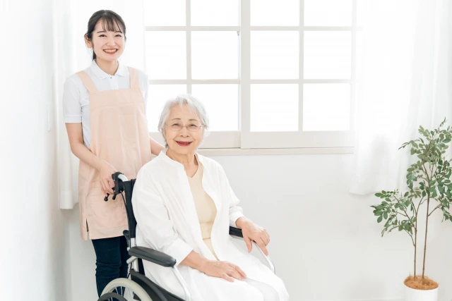 微笑む車いすの女性とスタッフ