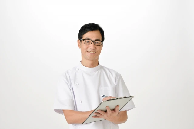 バインダーを手にする白衣の男性
