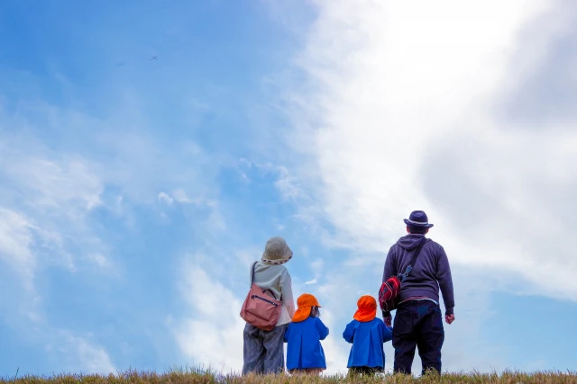 青空の下の大人と幼児