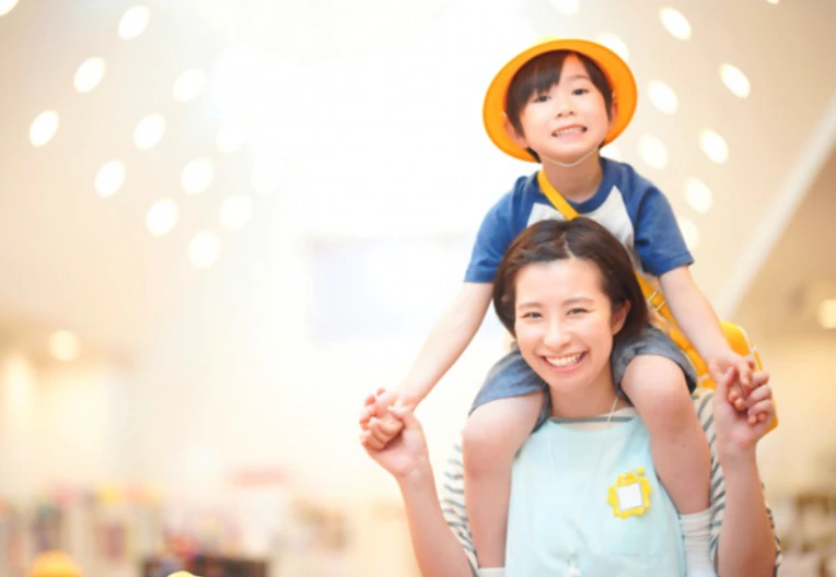 保育士と手をつなぐ子ども