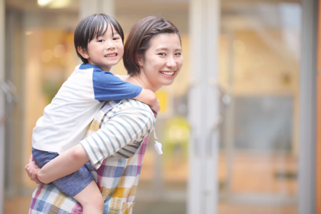 子どもをおんぶする保育士