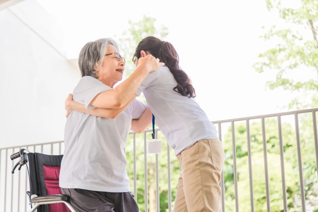 スタッフに介助される女性