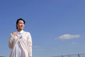 青空の下屋上に立っている看護師