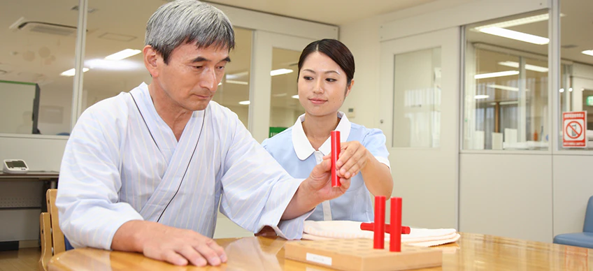 作業療法士が患者さんのリハビリテーションを行っている