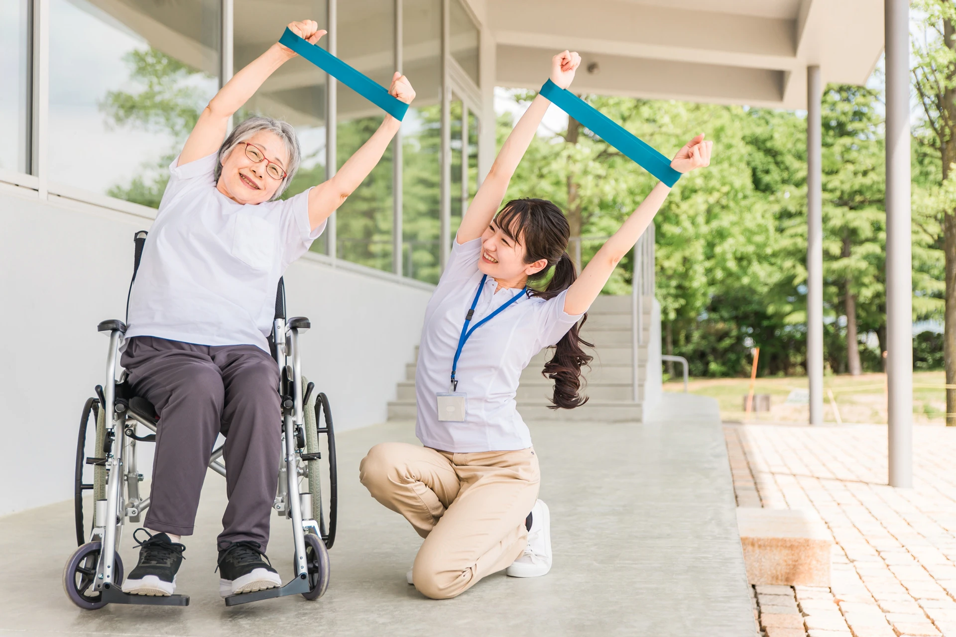 利用者さんと一緒にストレッチをする女性スタッフ