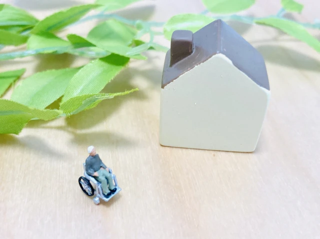 家と車いすの男性