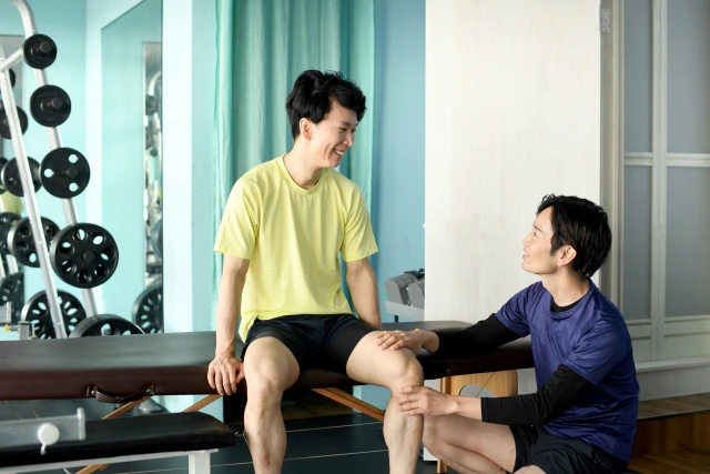 男性の脚を確認するスタッフ