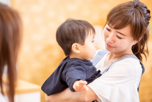 子どもを抱く保育士さん