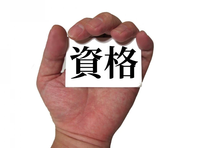 「資格」の文字と左手