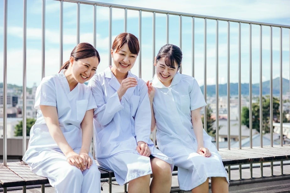 屋上で笑いあう３人の看護婦