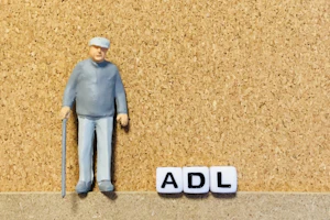 杖をついた男性の人形とADLの文字