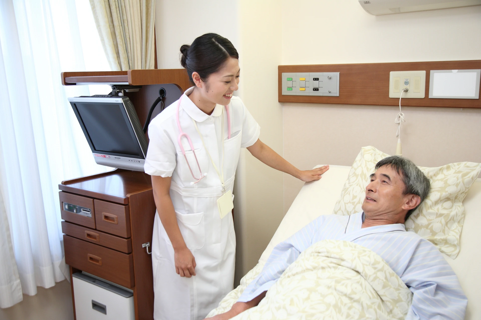 看護士さんとベッドに横たわる患者さん