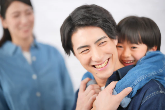 おんぶされる男の子と家族