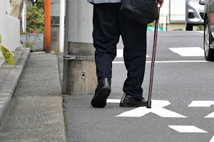 杖をついて歩く人