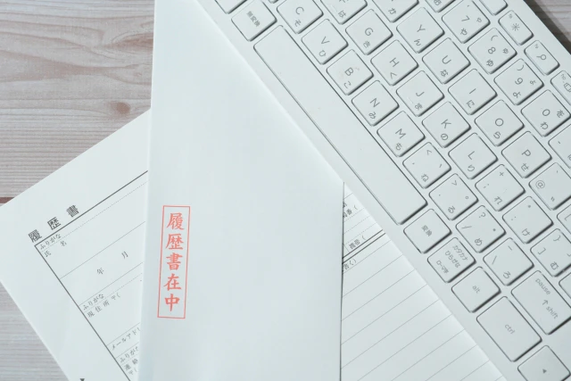 キーボード下の履歴書と封筒