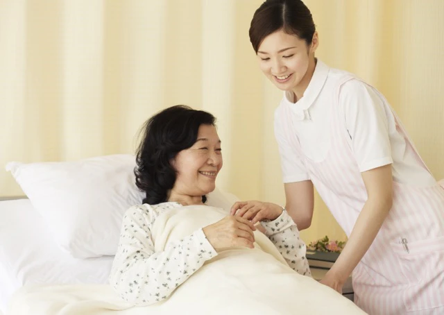 患者さんのベッドを起こそうとしている看護師