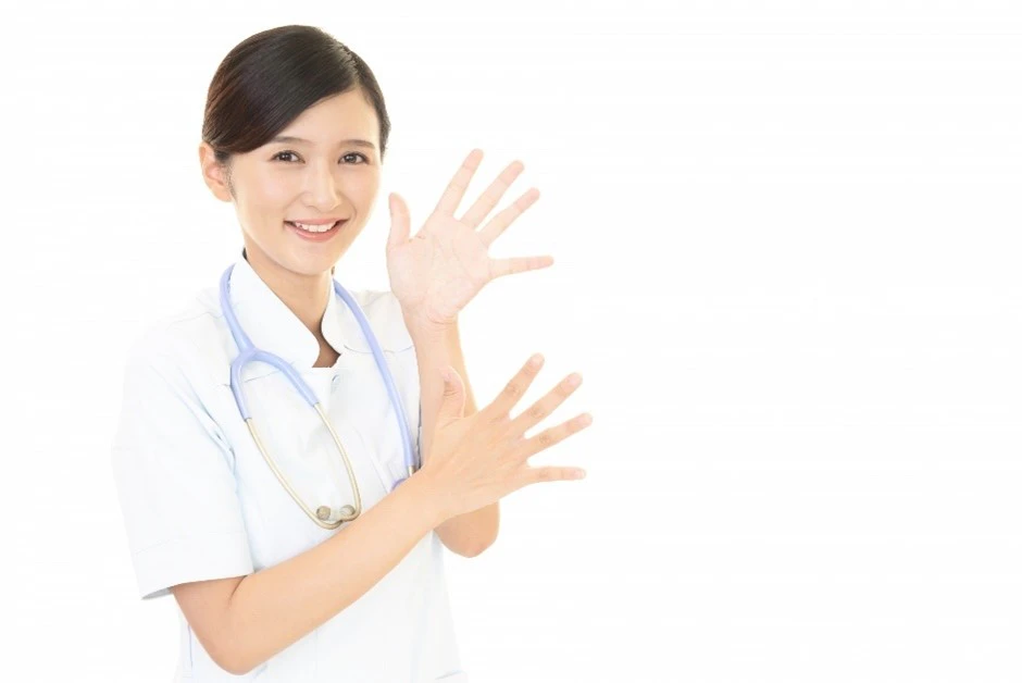 両手の指を広げる女性看護師