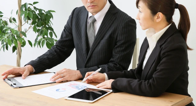 資料を見ながら話し合う男女のスタッフ