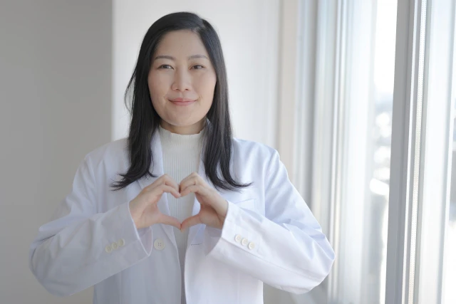 胸でハートを作る女性看護師