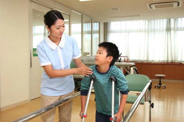 リハビリをしているこどものフォローをする看護師