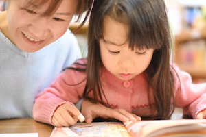 絵本を読む女の子と女性