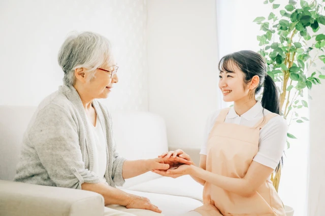 手を握るスタッフと患者さん