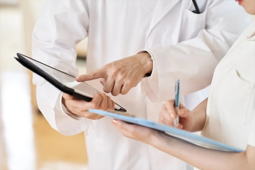 カルテを見ながら相談する医師と看護師