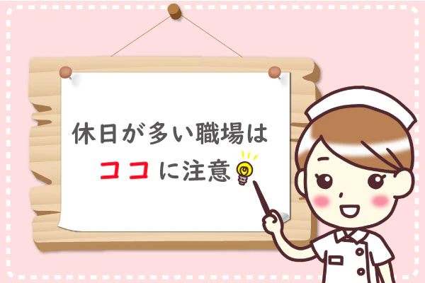 大きな掲示板に「休日が多い職場はここに注意」と書かれている。その前で看護師が掲示板の文字を指している。