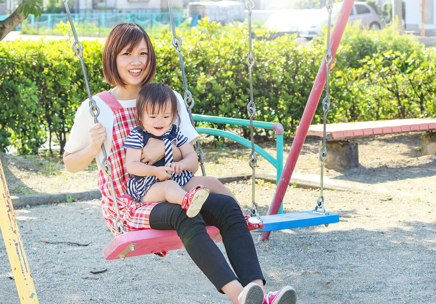 ブランコで遊ぶ保育士と子ども