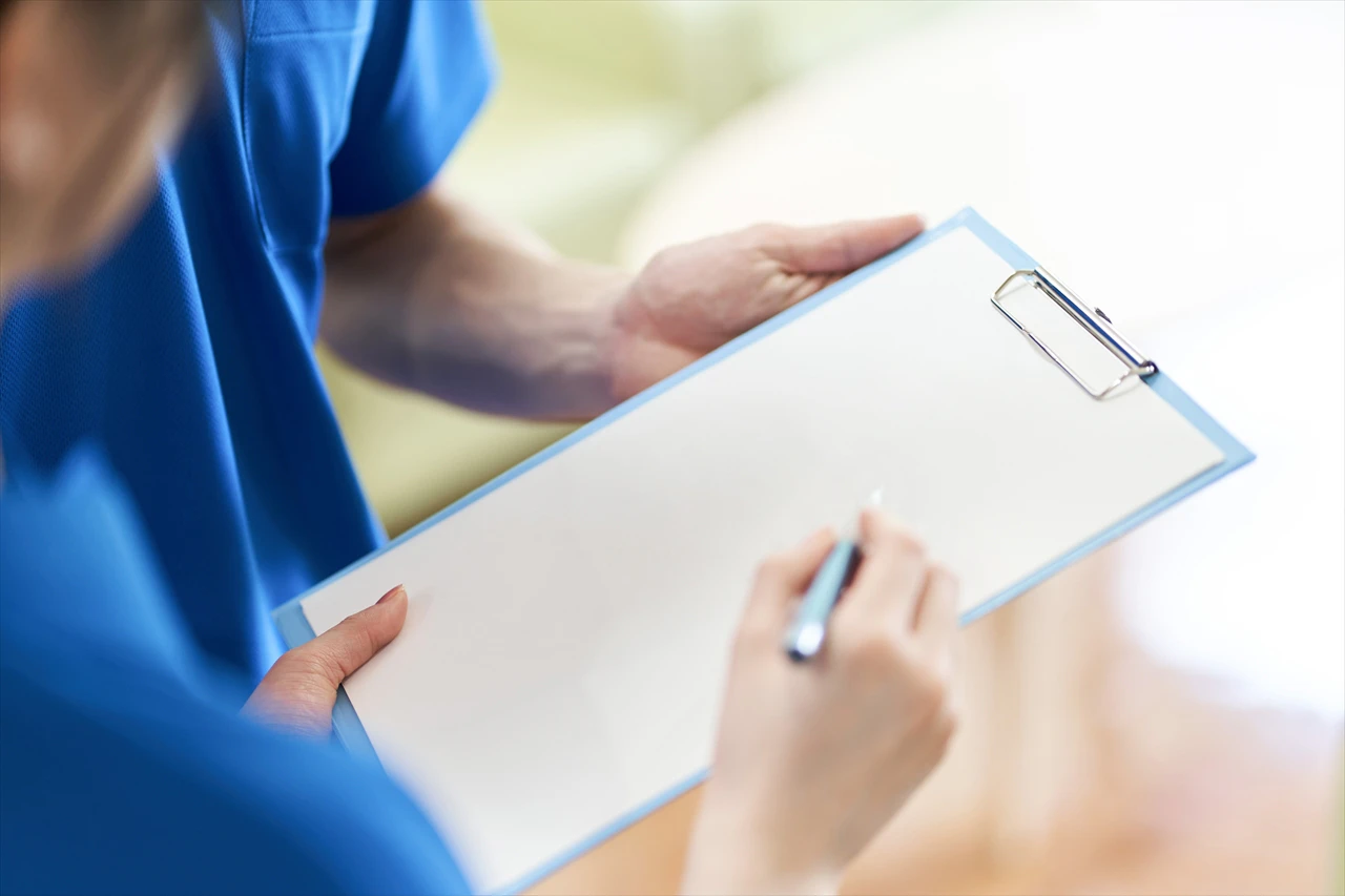 バインダーの紙に書く介護士
