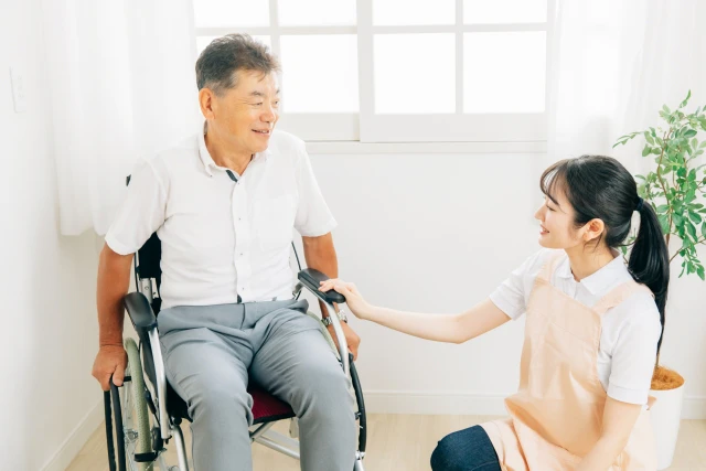 談笑する車椅子の男性とスタッフ
