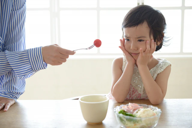 子どもにご飯を食べさせている