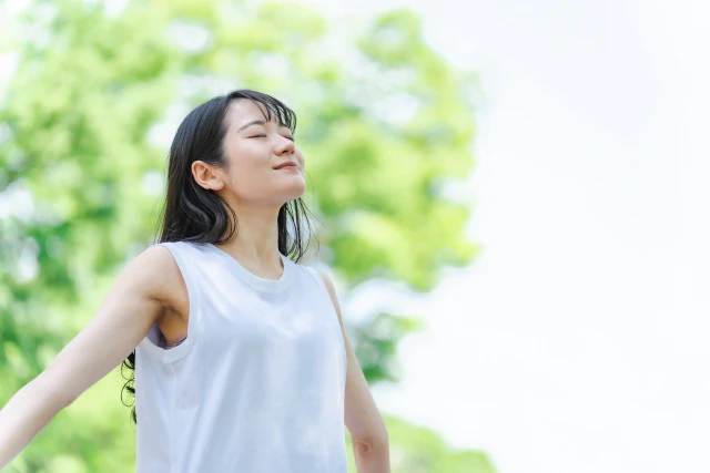 緑の中で深呼吸する女性