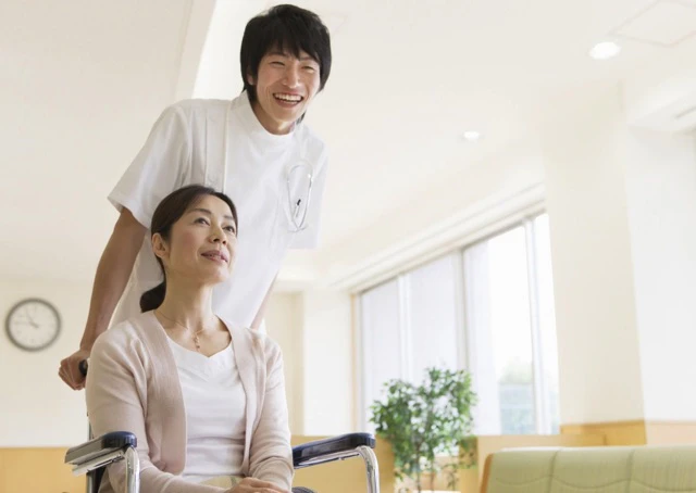 車いすを押している男性看護師