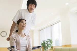 車いすを押している男性看護師