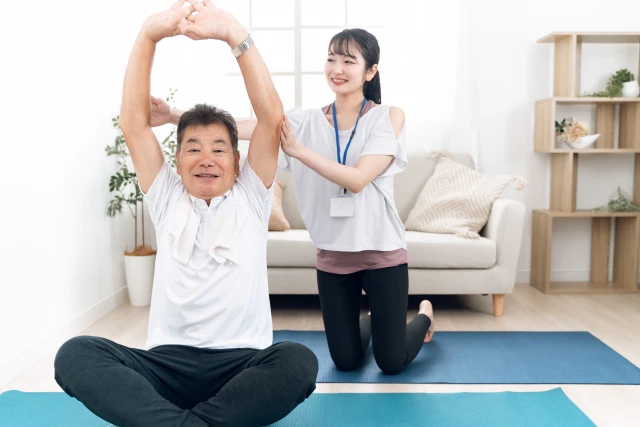 ストレッチをする男性とスタッフ