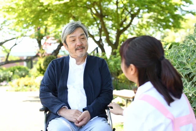 談笑する年配の男性と療法士さん