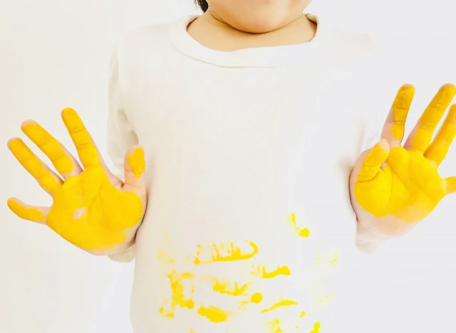 手に黄色い絵の具を塗った子供