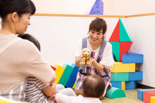 ぬいぐるみを使って園児をあやす保育士さん