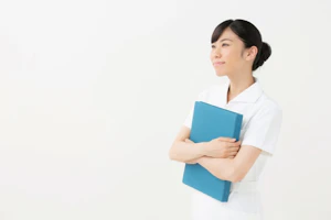 カルテを持って立っている看護師